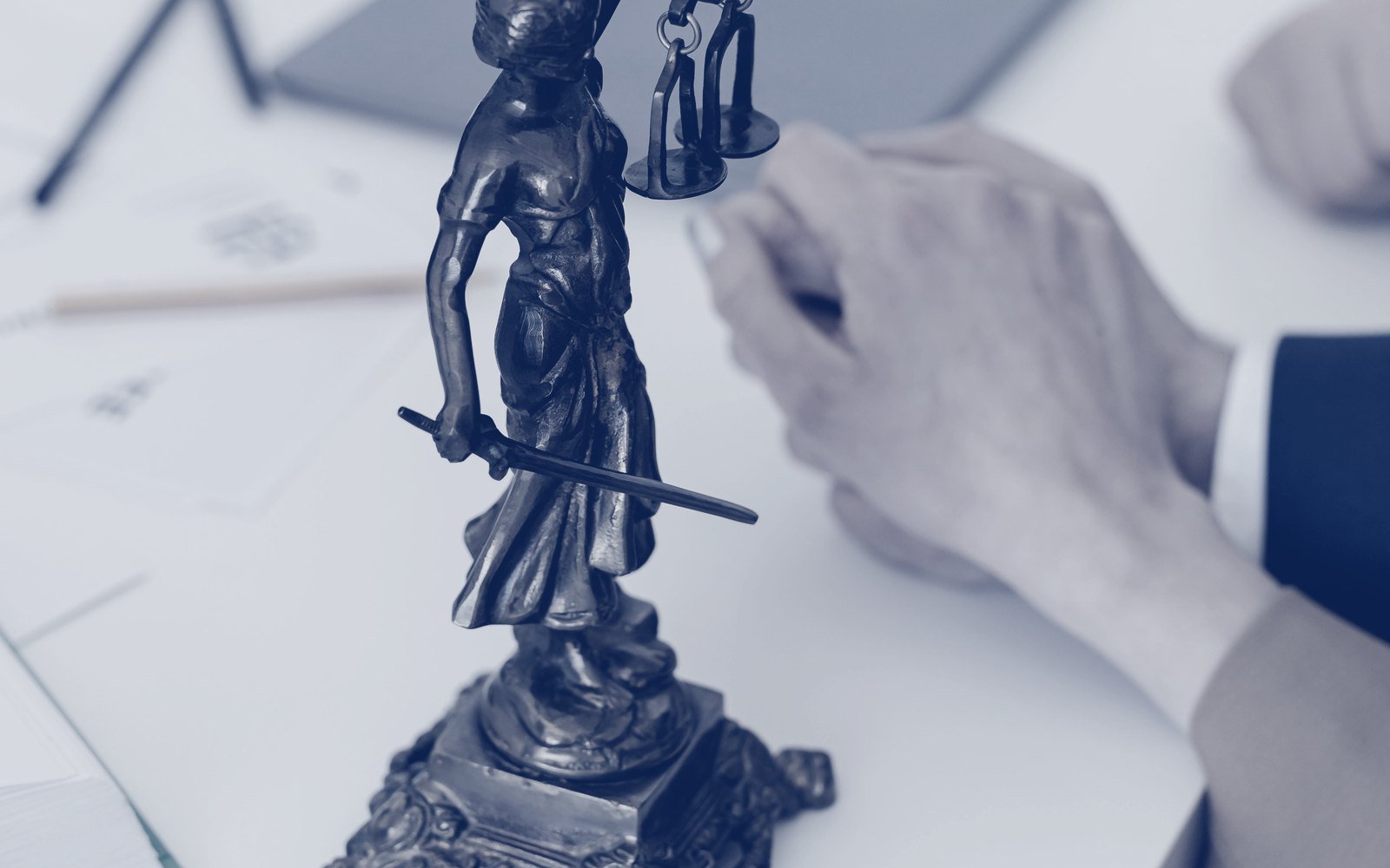Estatua de la justicia sobre una mesa de trabajo durante una asesoría legal
