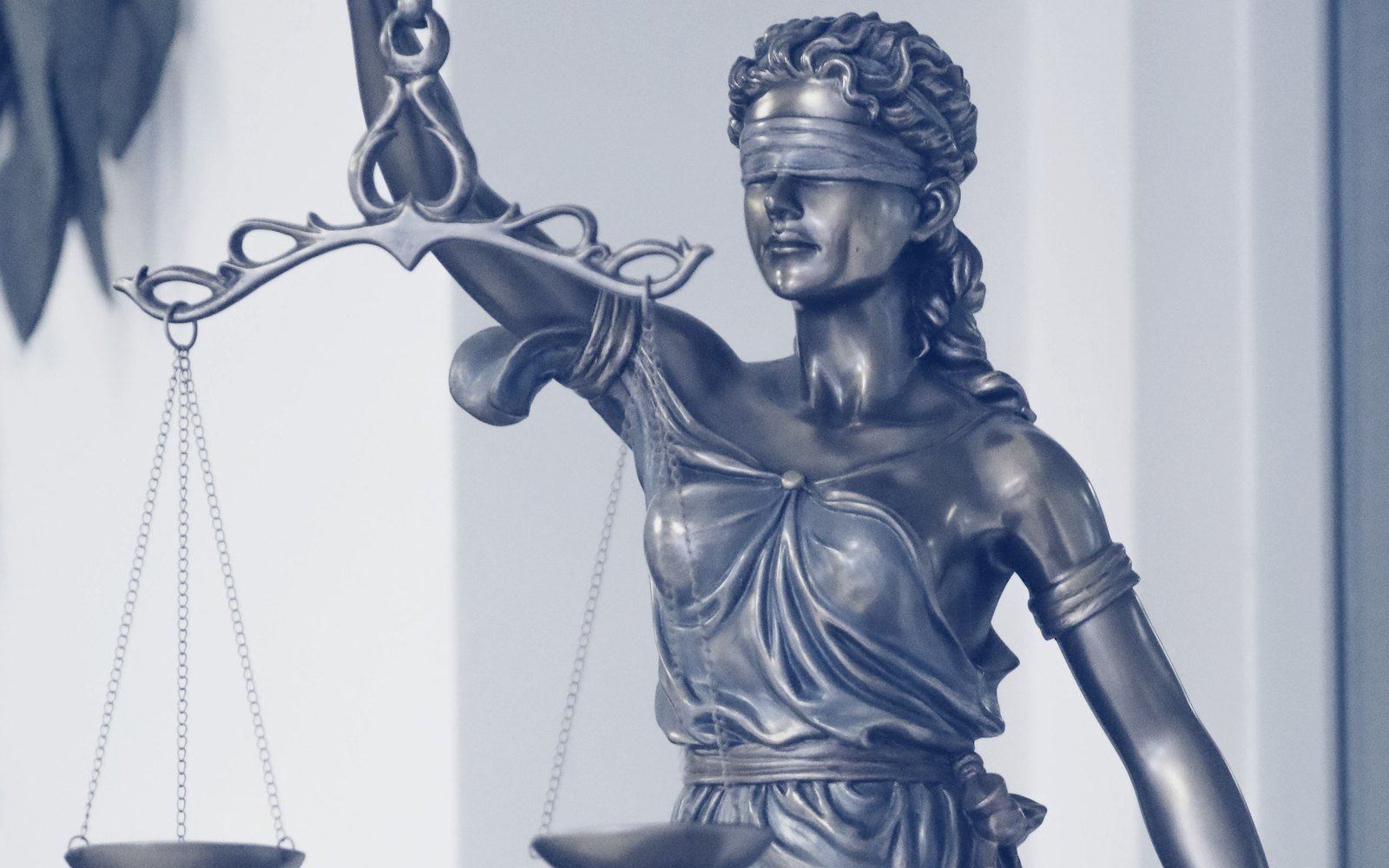 Figura de la justicia sosteniendo la balanza, en primer plano